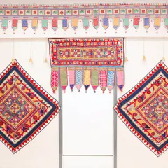 Detail shot of the beautiful, colorful embroidered textiles used to create a traditional toran or doorway decoration for the Gujarati ceremony. These handcrafted pieces add an authentic and vibrant touch to the event.