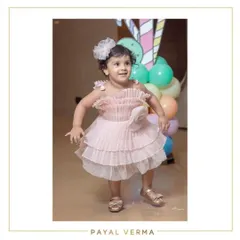 A full-length view of the pleated organza birthday dress. The lightweight fabric and soft color make it a beautiful and comfortable choice for a party, complete with a large, handcrafted organza flower detail.