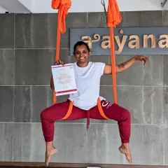 A proud graduate of our aerial TTC, holding her certificate while striking a pose in the hammock.