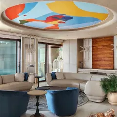 The fifth wall is my canvas. For this Mumbai home, I created a 14-foot abstract depiction of the city on the ceiling, turning the living room's sky into a vibrant ode to "Mumbai meri jaan".