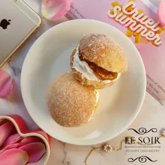 This is my Mango Cream Doughnut Sandwich, a seasonal special. It features two halves of a soft doughnut filled with fresh whipped cream and a sweet mango compote.