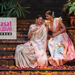 A campaign shot for Kasat Exclusive featuring their stunning sarees. The models are posed on stone steps adorned with flowers, creating a scene that is both traditional and contemporary.
