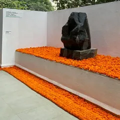 A sculpture by Stephen Cox is given a place of honor at the MAP preview, set against a bed of marigolds. This installation highlights the integration of cultural traditions and contemporary art within the museum's architectural framework.