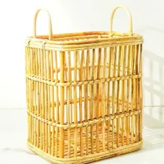 A rectangular, open-weave rattan basket with high handles. This lightweight and airy design is perfect for use as a laundry hamper, a storage basket for towels, or for carrying items around the home.