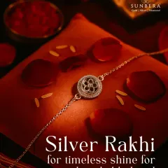A silver rakhi for a timeless shine and an unbreakable bond. This beautifully lit shot focuses on a single, elegant silver rakhi, highlighting its intricate floral design and the promise of forever it represents.