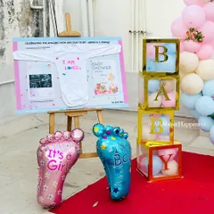 A close-up of the baby shower details, including 'It's a Girl' and 'It's a Boy' balloons, 'BABY' blocks, and a custom board with the baby's sonogram.