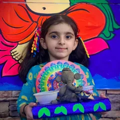 Another happy student with her finished Ganesha idol. Each child adds their own unique touch, from the decorations on the base to the colors they choose, making every creation special.