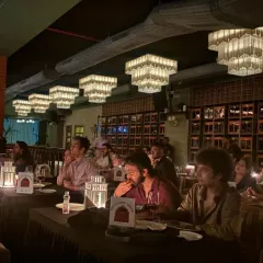 A candid moment from our ZNMD night in Mumbai. The focus is on the screen, but the tables are set for a culinary journey, with wine and the first course ready, showing how we seamlessly blend dining with viewing.