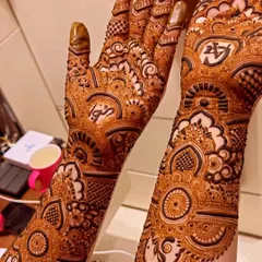 Even non-bridal or guest mehendi can be personalized. This close-up shows the initials 'A' and 'S' cleverly integrated into a dense, symmetrical pattern on the wrist and hand.