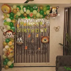 A simple jungle-themed decoration perfect for home celebrations. This setup includes a balloon arch with animal head foil balloons and a silver fringe curtain for the backdrop.