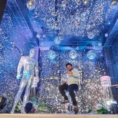 This image shows the scale of the shimmer wall installation, which even covers the ceiling. The addition of a mirrored mannequin and spotlights enhances the futuristic, high-glam theme.