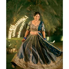 A full-length portrait of the bride twirling in her stunning blue and gold lehenga during her Mehendi ceremony. The outdoor setting with fairy lights adds a magical touch to the evening.