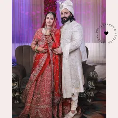 A classic, formal portrait of the bride and groom on their wedding day. Their regal outfits and poised stances create a timeless and elegant memory.