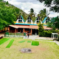 A view of our beautiful A-frame cottages at the Nandi Hills resort. These unique structures offer a comfortable stay with a great view of the lawn and surrounding greenery.
