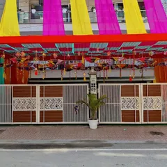 A straight-on shot of the decorated entrance gate. The combination of the overhead tent and the bright colors makes the house stand out for the special occasion.