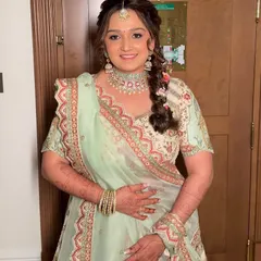 The bride looking radiant and happy in her pastel green wedding lehenga. The makeup is soft and glowing, with a focus on her beautiful eyes.