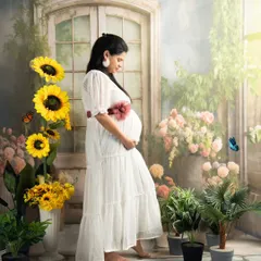 A dreamy, garden-inspired portrait. The soft light, beautiful flowers, and the simple white dress come together to create a truly magical maternity photo.