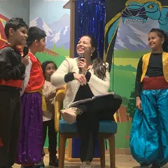 An instructor shares a laugh with the young cast members. I guide the children through every step of the production, from learning lines to stage presence, in a fun and supportive way.