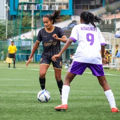 A player demonstrates excellent dribbling skills, confidently taking on a defender in a one-on-one situation during a youth championship match.