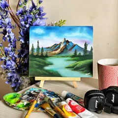 A finished landscape painting, capturing a quiet moment in nature. In my classes, I teach how to use acrylics to create depth and atmosphere, turning a blank canvas into a window to another world. All the supplies you see here are what we use in our sessions.