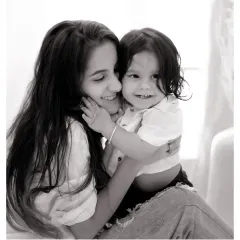 A sweet, smiling hug between a mother and her son. This black and white portrait has a timeless feel, focusing on their happy and loving bond.