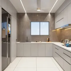 A U-shaped kitchen designed for ultimate functionality with seamless, light grey handleless cabinets and a smart refrigerator. The design prioritizes a clean, uncluttered look with under-cabinet lighting and a durable, solid-surface countertop.