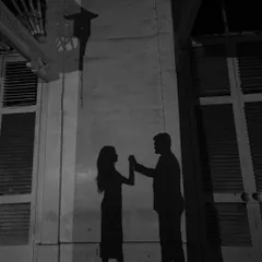 A creative use of shadow play, creating a silhouette of the couple dancing. This is storytelling through light and its absence.