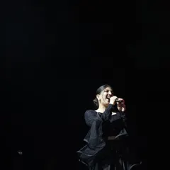 A dramatic shot of me against a black background, with the spotlight catching my smile. This captures the magic of being on stage.
