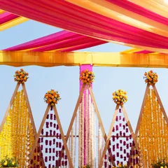 Detail shot of the triangular backdrop panels, showcasing the intricate patterns created with fresh flower garlands for this beautiful Haldi ceremony.