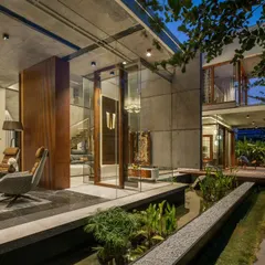 This contemporary puja room at The Quarry House is a glass-enclosed sanctuary set over a water body. The design fosters a sense of tranquility and connection to the five elements.