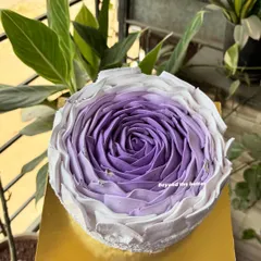 A close up of the purple ombre buttercream rose cake, showing the delicate petal work and textured sides.
