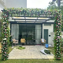 We also decorate outdoor spaces like patios and pergolas. Here, we covered the structure with a thick arrangement of mixed flowers and greens, creating a beautiful setting for a garden party or daytime event.