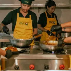 The NCF team working together, cooking multiple dishes at once to get your orders ready on time.