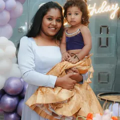 For clients who love traditional wear, I create coordinated sets like this one. The daughter is dressed in a custom pattu lehenga with a modern velvet blouse, complementing her mother's simple yet elegant gown for a family celebration.