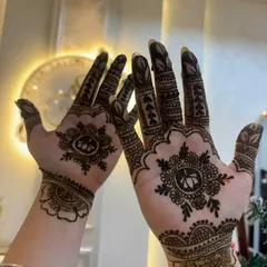 Here is a beautiful example of symmetrical mehendi art featuring a lotus motif at the center. The design is detailed yet uncluttered, extending from the wrist to the fingertips, making it ideal for festive occasions.