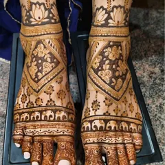 A lovely bridal foot design with rows of small elephants, floral patterns, and a lotus cuff around the ankle. It's a traditional and auspicious design for any bride.