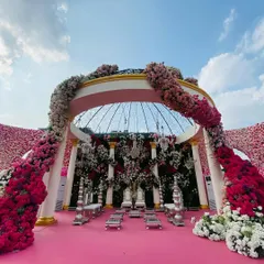 A wide view of the pink floral mandap, showcasing the sheer scale and opulence of the design. The cascading flowers and grand structure create an unforgettable setting for a dream wedding.