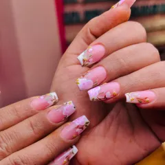 A garden at your fingertips. This beautiful design features delicate pink cherry blossoms with gold leaf accents, painted over a modern French tip base.
