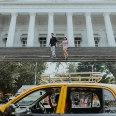 A dynamic two-panel shot showing the couple on the steps of the Asiatic Society Library, contrasted with a candid reflection in a classic Mumbai taxi, telling a story of the city.