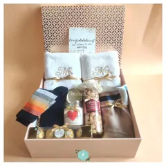 Welcoming a new couple into the family with a warm and thoughtful hamper. It features embroidered "Mr & Mrs" towels, cozy socks, a scented candle, and delicious treats.