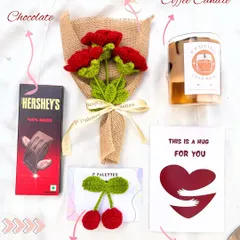 Our "Hug For You" hamper, featuring a dark chocolate bar, a handmade red rose bouquet, a coffee-scented candle, a cherry hair clip, and a sweet greeting card.