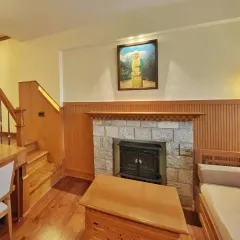 The cozy seating area in the Gangtok suite, complete with a stone-clad fireplace. This space is designed to be a warm retreat after a day of exploring the mountains.
