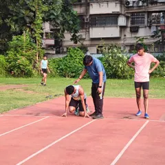 I am correcting an athlete's posture in the starting blocks. A strong and stable setup is fundamental for a powerful start.