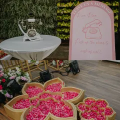 We love adding unique, interactive details. This corner features a vintage telephone for an audio guestbook, where guests can leave heartfelt messages, alongside beautiful flower-shaped trays holding fresh rose petals for rituals.