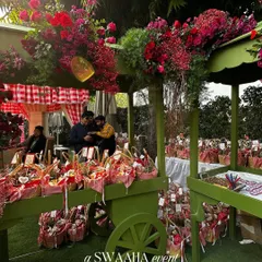 A beautifully styled cart overflowing with flowers and picnic basket favors, adding to the charming, rustic theme of the baby shower.