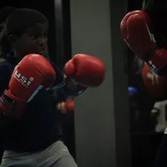 A young fighter throwing a jab during a drill. The focus and determination in his eyes show the champion's mindset we build from day one.