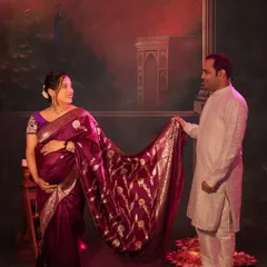 A classic pose showcasing the beautiful Banarasi saree. The painted backdrop adds a touch of royal elegance to this ethnic-themed shoot.