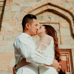 An intimate kiss in front of the historic stone architecture of Delhi. This destination pre-wedding shoot blends romance with the rich cultural heritage of the location.
