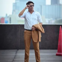 This shot has a candid feel, as if the subject is adjusting his sunglasses. It adds a touch of personality to a professional portfolio, showing confidence against the urban city background.