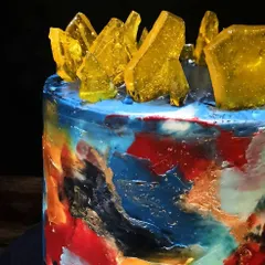 A close-up view of the edible canvas cake. You can see the layers of color and texture I created with buttercream, highlighted with touches of edible gold paint.